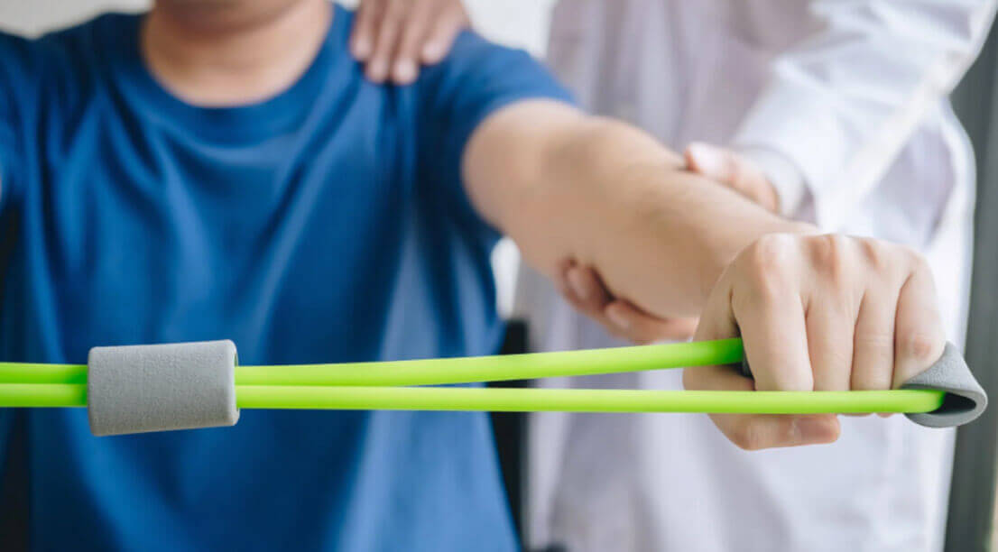 A close-up shows a person using a resistance band during a guided physical therapy session, emphasizing recovery and strength building.